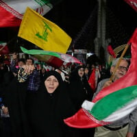 People wave the flags of Iran and its Lebanese proxy Hezbollah at a pro-regime rally in Tehran, Iran, on October 8, 2026. (AP Photo/Vahid Salemi)
