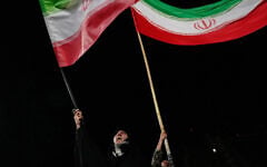 Demonstrators wave Iranian flags during a pro-government gathering at a square in Tehran, Iran, October 8, 2026. (AP Photo/Vahid Salemi)