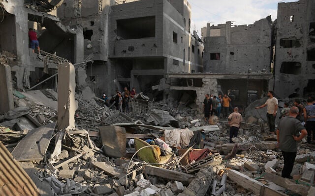 Palestinians inspect a building destroyed in an Israeli airstrike late on Thursday in Khan Younis, southern Gaza Strip, October 9, 2026. (AP Photo/Abdel Kareem Hana)