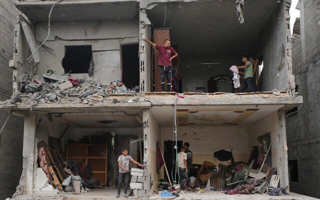 Palestinians salvage their belongings from a building destroyed by an Israeli airstrike in Gaza City, October 9, 2026. (AP Photo/Jehad Alshrafi)