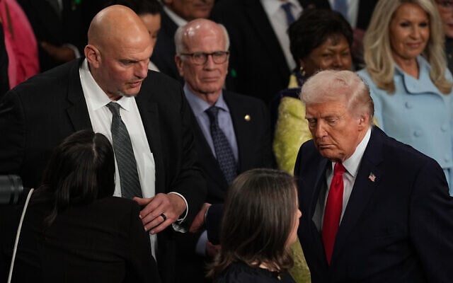 President Donald Trump passes Sen. John Fetterman as he departs after delivering the State of the Union address to a joint session of Congress in the House chamber at the US Capitol in Washington, February 24, 2026. (AP Photo/Matt Rourke) President Donald Trump passes Sen. John Fetterman as he departs after delivering the State of the Union address to a joint session of Congress in the House chamber at the US Capitol in Washington, February 24, 2026. (AP Photo/Matt Rourke)