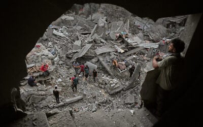 Palestinians inspect a building destroyed in an Israeli airstrike late Saturday in Zawaida, central Gaza Strip, October 11, 2026. (AP Photo/Abdel Kareem Hana)