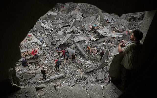 Palestinians inspect a building destroyed in an Israeli airstrike late Saturday in Zawaida, central Gaza Strip, October 11, 2026. (AP Photo/Abdel Kareem Hana)