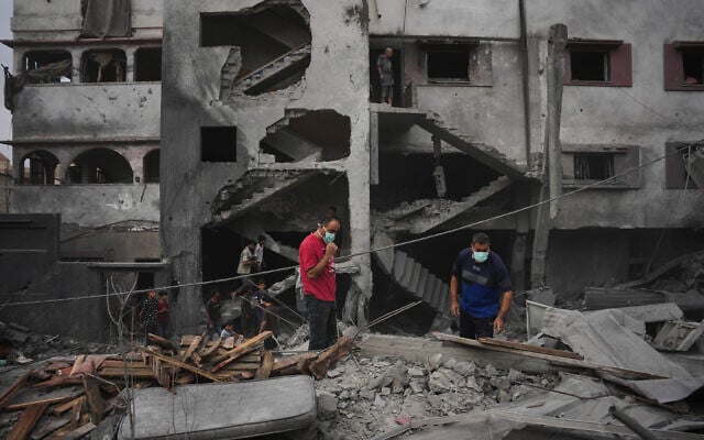 Palestinians inspect a building destroyed in an Israeli airstrike in Zawaida, central Gaza Strip, October 11, 2026. (AP Photo/Abdel Kareem Hana)