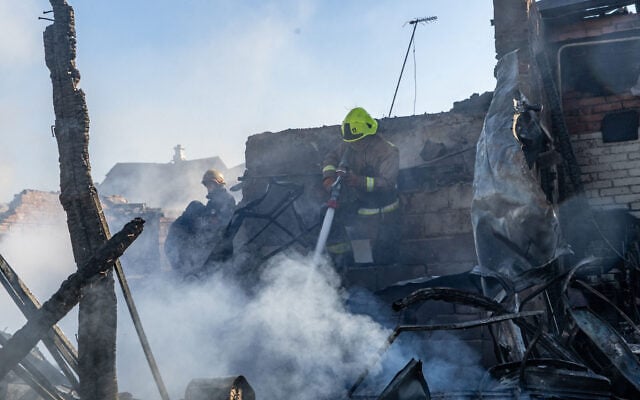 Rescue workers put out a fire at residential buildings destroyed in a Russian strike on Kharkiv, Ukraine, October 11, 2026. (AP Photo/Andrii Marienko)