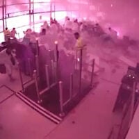 This image from CCTV video released by Saudi Arabia’s Media Ministry shows passengers taking cover as flames and smoke fill part of King Khalid International Airport in Riyadh, Saudi Arabia, during what authorities described as a strike at the airport on October 10, 2026. (Saudi Media Ministry via AP)