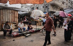 Palestinians walk through a market in the Al-Shati refugee camp in Gaza City on October 14, 2026. (AP Photo/Abdel Kareem Hana)