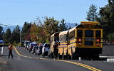 School buses are lined up outside Silver Rail Elementary school, where a deadly shooting took place, on October 15, 2026, in Bend, Oregon. (AP Photo/Joe Kline)