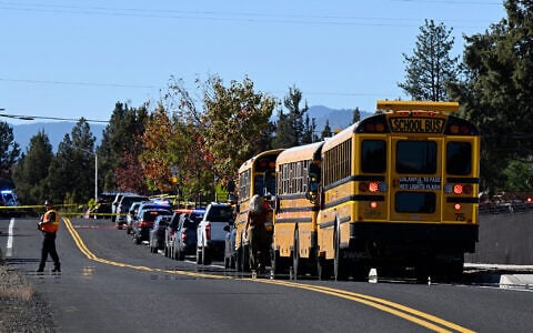 School buses are lined up outside Silver Rail Elementary school, where a deadly shooting took place, on October 15, 2026, in Bend, Oregon. (AP Photo/Joe Kline)