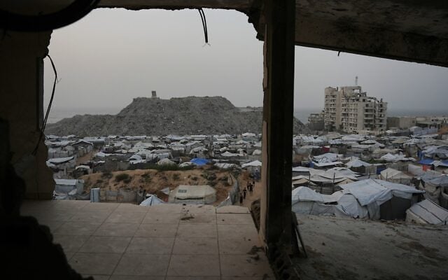 Palestinians walk among tents at a tent camp for displaced people in Gaza City, October 16, 2026. (AP Photo/Abdel Kareem Hana)