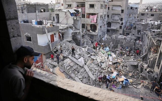 A man looks as Palestinians search through the rubble of a building destroyed in an Israeli airstrike the day before in the Maghazi camp in the central Gaza Strip, October 16, 2026. (AP Photo/Abdel Kareem Hana)
