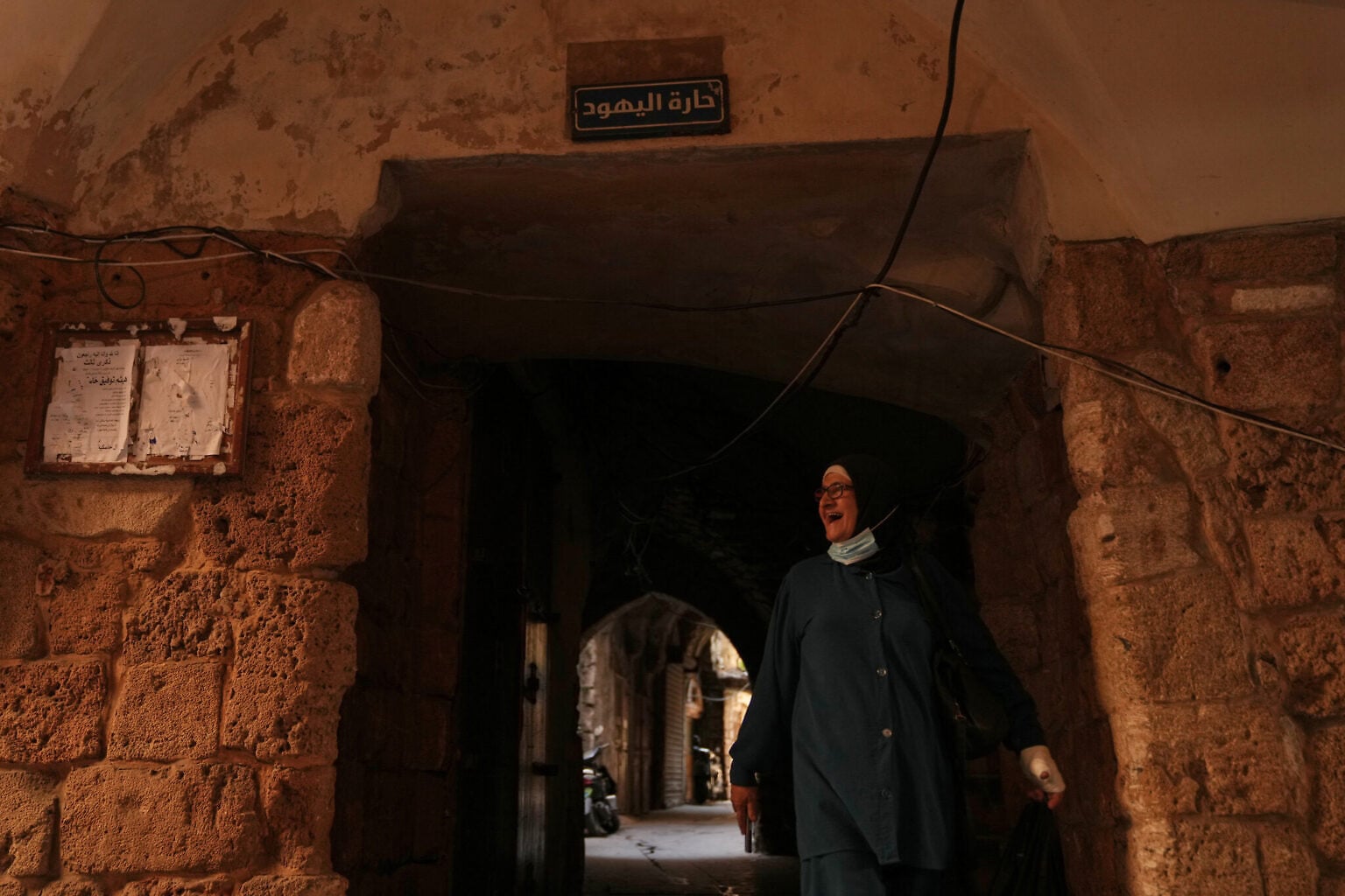 A woman walks beneath a sign that reads in Arabic “Jewish Quarter,” in the old city of Sidon, southern Lebanon, September 25, 2026. (AP Photo/Hassan Ammar)