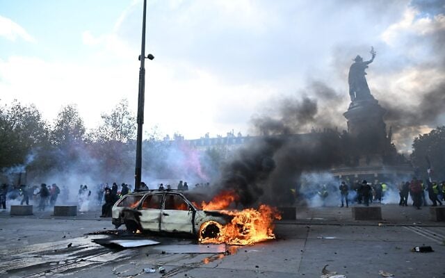 A car burns at Place de La Republique during a protest against rising living costs in Paris, October 17, 2026. (AP Photo/Emma Da Silva)