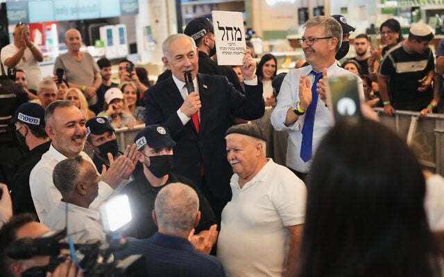 Prime Minister Benjamin Netanyahu, leader of the Likud party, speaks with supporters while he campaigns ahead of the country’s general election at a shopping mall in Ramla, October 19, 2026. (AP/Ariel Schalit)