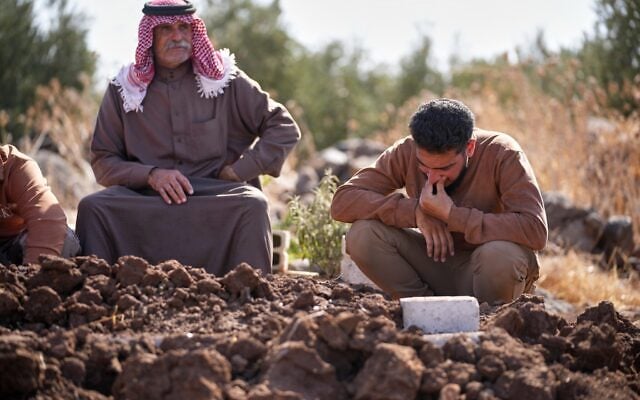Mourners gather beside the grave of Muath Salama al-Baeer, a young man with a disability who state media said was killed during an early morning Israeli military incursion, during his funeral in Jamla, in the Yarmouk Basin area of western Daraa province, Syria, October 22, 2026. (AP Photo/Ghaith Alsayed)