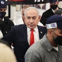 Prime Minister Benjamin Netanyahu, leader of the Likud party, is surrounded by security personnel during a campaign appearance at a market in Tel Aviv, Israel, October 22, 2026, ahead of the country’s general election. (AP Photo/Ariel Schalit)
