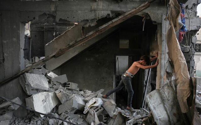 A Palestinian boy makes his way through the rubble of a home destroyed in an overnight Israeli strike in Nuseirat, in the central Gaza Strip, October 23, 2026. (AP Photo/Abdel Kareem Hana)