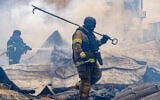 Rescuers work on the roof of a damaged building following Russia’s air attack in Kharkiv, Ukraine, October 23, 2026. (AP Photo/Andrii Marienko)