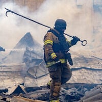 Rescuers work on the roof of a damaged building following Russia’s air attack in Kharkiv, Ukraine, October 23, 2026. (AP Photo/Andrii Marienko)