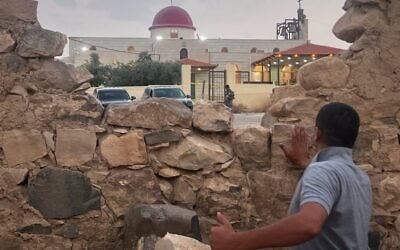 A man looks through a gap in a stone wall toward a Greek Orthodox church where gunmen opened fire during a funeral hours earlier in Hamoud village, in Jordan’s Karak governorate, October 23, 2026. (AP Photo) A man looks through a gap in a stone wall toward a Greek Orthodox church where gunmen opened fire during a funeral hours earlier in Hamoud village, in Jordan’s Karak governorate, October 23, 2026. (AP Photo)