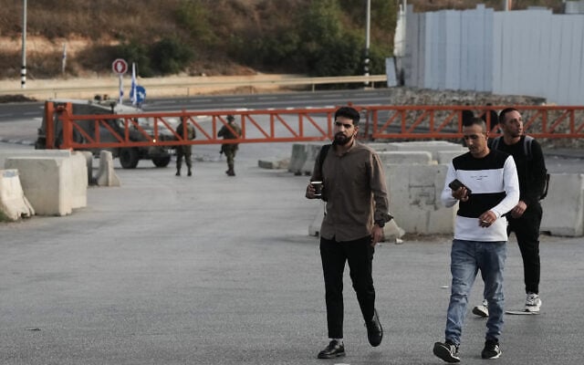 Palestinians cross on foot past a military gate closed to vehicles during an Israeli army operation in Hebron in the West Bank October 24, 2026, a day after a Palestinian shooting attack in the area. (AP Photo/Mahmoud Illean)