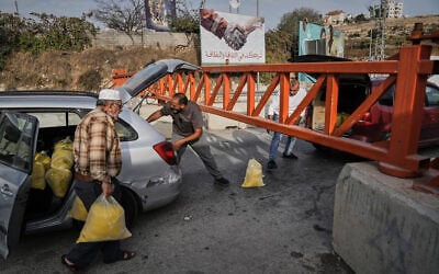 Palestinians transport bags of semolina past a military gate closed to vehicles during an Israeli army operation in Hebron, in the West Bank, October 24, 2026, a day after two IDF soldiers were killed by Palestinian gunmen in the area. (AP Photo/Mahmoud Illean) Palestinians transport bags of semolina past a military gate closed to vehicles during an Israeli army operation in Hebron, in the West Bank, October 24, 2026, a day after two IDF soldiers were killed by Palestinian gunmen in the area. (AP Photo/Mahmoud Illean)