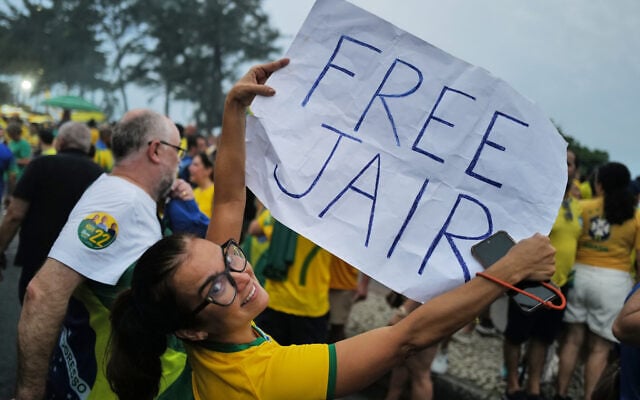 A supporter of opposition presidential candidate Sen. Flavio Bolsonaro holds a sign that reads 'Free Jair,' referring to his father, former Brazilian president Jair Bolsonaro, during his final campaign rally a day before the presidential runoff election in Rio de Janeiro, October 24, 2026. (AP Photo/Lucas Landau)