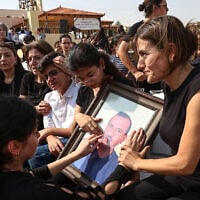 Relatives mourn as they hold a framed portrait of a victim killed in an attack on a Greek Orthodox church during a funeral ceremony in Karak, Jordan, October 25, 2026. (AP Photo/Raad Adayleh)