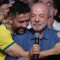 Brazilian lawmaker Andre Janones embraces President Luiz Inacio Lula da Silva as he delivers a victory speech after winning a fourth term in the presidential runoff in Brazil, October 25, 2026. (AP Photo/Andre Penner)