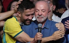 Brazilian lawmaker Andre Janones embraces President Luiz Inacio Lula da Silva as he delivers a victory speech after winning a fourth term in the presidential runoff in Brazil, October 25, 2026. (AP Photo/Andre Penner)