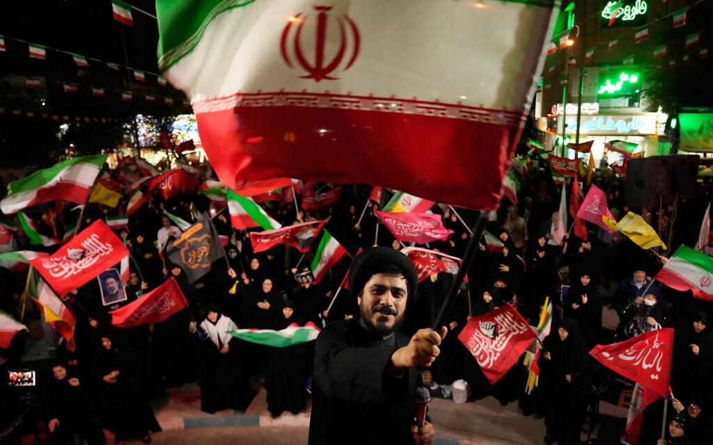 A cleric waves an Iranian flag while leading demonstrators during a pro-government gathering in Tehran, Iran, October 27, 2026. (AP/Vahid Salemi) A cleric waves an Iranian flag while leading demonstrators during a pro-government gathering in Tehran, Iran, October 27, 2026. (AP/Vahid Salemi)