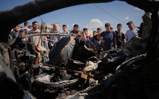 Palestinians inspect the wreckage of a vehicle destroyed in an Israeli airstrike in the Maghazi refugee camp in the central Gaza Strip, October 29, 2026. (AP Photo/Abdel Kareem Hana)