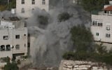 Smoke, dust and debris rise as the Israeli army demolishes two houses with explosives in connection with an October 23 shooting attack that killed two Israeli soldiers, in the West Bank city of Hebron, October 30, 2026. (AP/Mahmoud Illean)