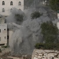 Smoke, dust and debris rise as the Israeli army demolishes two houses with explosives in connection with an October 23 shooting attack that killed two Israeli soldiers, in the West Bank city of Hebron, October 30, 2026. (AP/Mahmoud Illean)