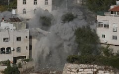 Smoke, dust and debris rise as the Israeli army demolishes two houses with explosives in connection with an October 23 shooting attack that killed two Israeli soldiers, in the West Bank city of Hebron, October 30, 2026. (AP/Mahmoud Illean)