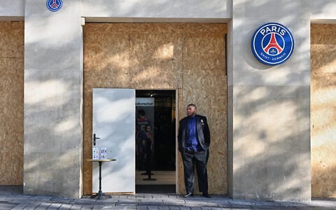 A man stands in front of a barricaded shop of the soccer team Paris Saint-Germain before protests in Paris, France, October 31, 2026. (AP Photo/Emma Da Silva)