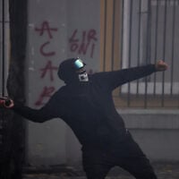 A protester throws a petrol bomb at police during an anti-government rally, in Tirana, Albania, October 31, 2026. (AP Photo/Hameraldi Agolli)