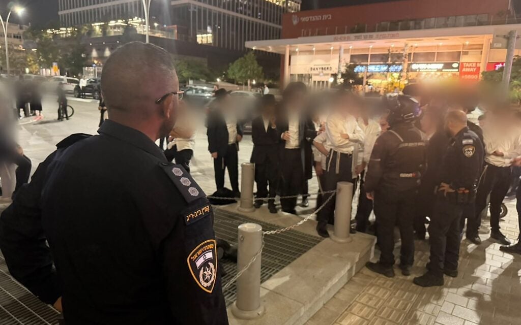 Police face off against ultra-Orthodox protesters outside an office building housing an IDF program in Bnei Brak, October 14, 2026. (Israel Police)