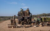 Combat support soldiers are seen loading explosives onto an army vehicle outside the Paga military post on the border with the Gaza Strip, December 15, 2023. (Emanuel Fabian/Times of Israel)