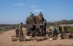 Combat support soldiers are seen loading explosives onto an army vehicle outside the Paga military post on the border with the Gaza Strip, December 15, 2023. (Emanuel Fabian/Times of Israel)