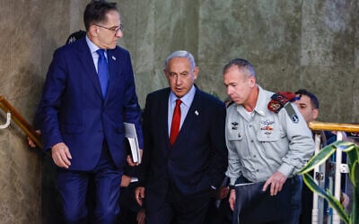 Prime Minister Benjamin Netanyahu arrives for a cabinet meeting at the Prime Minister’s Office in Jerusalem on January 22, 2023. At right is his military secretary, Maj. Gen. Avi Gil. At left is his chief of staff Tzachi Braverman. (Olivier Fitoussi/FLASH90)