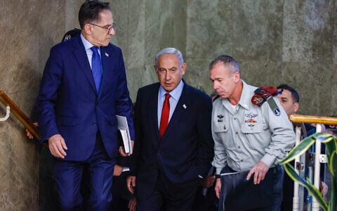 Prime Minister Benjamin Netanyahu arrives for a cabinet meeting at the Prime Minister’s Office in Jerusalem on January 22, 2023. At right is his military secretary, Maj. Gen. Avi Gil. At left is his chief of staff Tzachi Braverman. (Olivier Fitoussi/FLASH90)