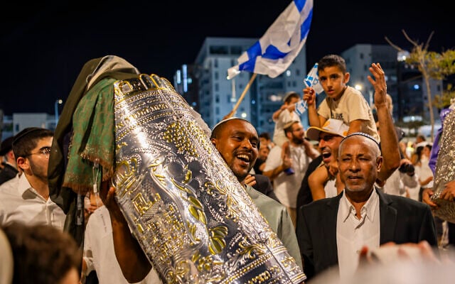 Jewish men carry Torah scrolls and dance during Simchat Torah celebrations in Haifa, October 3, 2026. (Sharon Leibel/Flash90)
