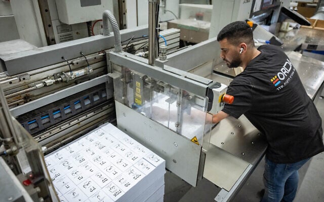 Workers print and arrange newly produced ballot papers at a printing factory in Kiryat Gat, in preparation for Israel’s upcoming general election, October 5, 2026. (Yonatan Sindel/Flash90)