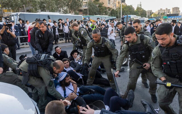 Ultra-Orthodox Jewish men block a road and clash with police during a protest against the jailing of yeshiva students who failed to comply with an army recruitment order, in Jerusalem, October 8, 2026. (Chaim Goldberg/Flash90)