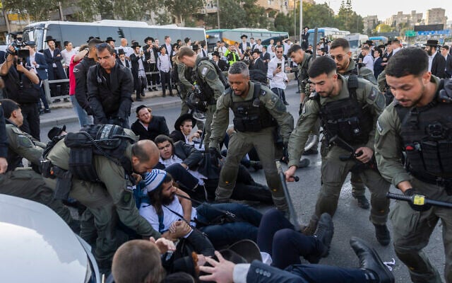 Haredi men block a road and clash with police during an anti-enlistment protest in Jerusalem on October 8, 2026. (Chaim Goldberg/Flash90)