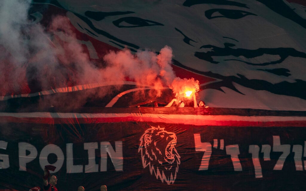Fans light a flare by a manner honoring murdered hostage Hersh Goldberg-Polin at a game between Hapoel Jerusalem and Maccabi Haifa at the Teddy Stadium in Jerusalem on October 12, 2026. (Oren Ben Hakoon/Flash90) Fans light a flare by a manner honoring murdered hostage Hersh Goldberg-Polin at a game between Hapoel Jerusalem and Maccabi Haifa at the Teddy Stadium in Jerusalem on October 12, 2026. (Oren Ben Hakoon/Flash90)