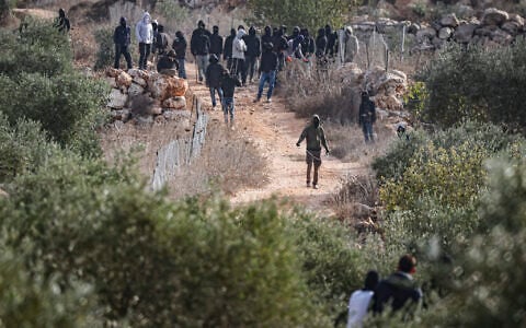 Masked extremist Jewish settlers clash with Palestinians during the annual olive harvest in the village of Abu Falah, near Ramallah in the West Bank, where several people, including American photojournalist Heidi Levine, were injured in an attack by Israeli settlers, October 16, 2026. (Flash90)