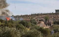 FILE: Masked extremist Jewish settlers clash with Palestinians during the annual olive harvest in the village of Abu Falah, near Ramallah in the West Bank, where several people, including American photojournalist Heidi Levine, were injured in an attack by Israeli settlers, October 16, 2026. (Flash90)