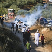 Israeli forces fire tear gas at Palestinian farmers, preventing them from continuing the olive harvest as they attempt to cross an iron gate erected by the Israeli army in the village of Salem, east of Nablus in the West Bank, October 17, 2026. (Nasser Ishtayeh/Flash90)
